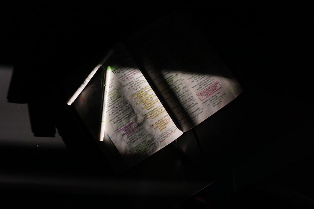 Magnifying glass resting on an open old book with handwritten notes in dim light